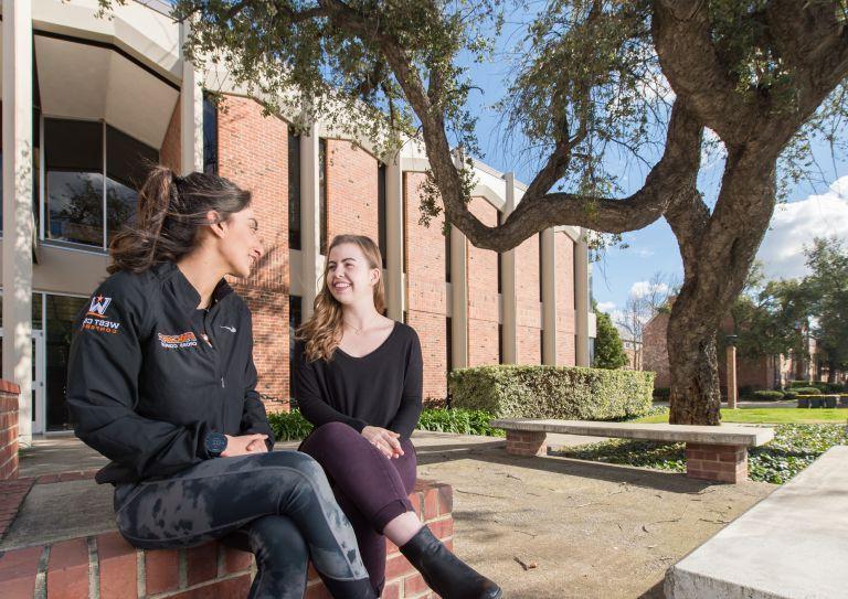two students sitting on campus
